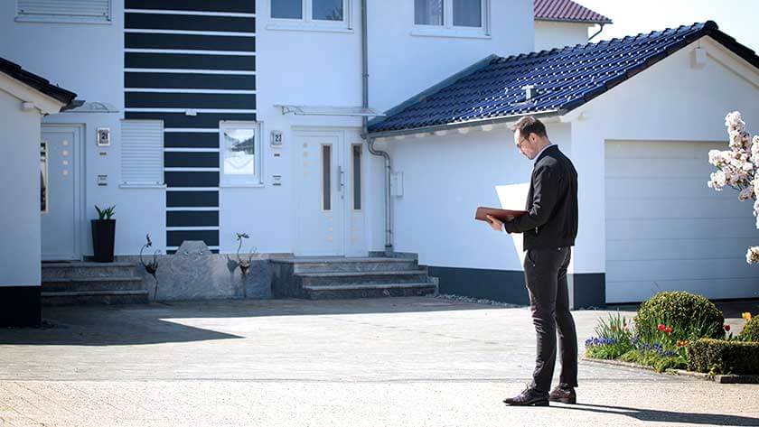 man-standing-outside-home-with-clipboard 
